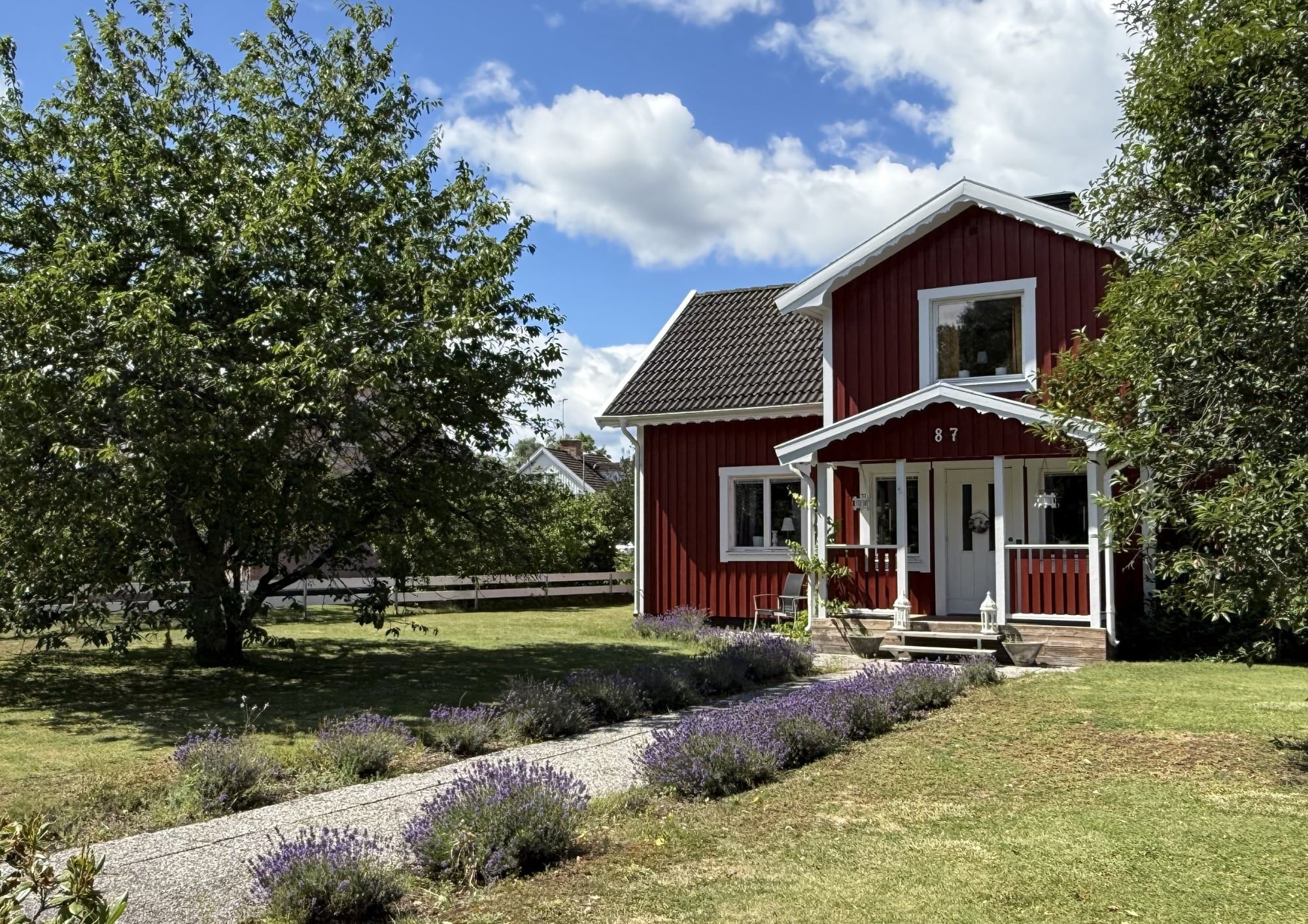 Rotes Holzhaus mit Veranda und Lavendelweg